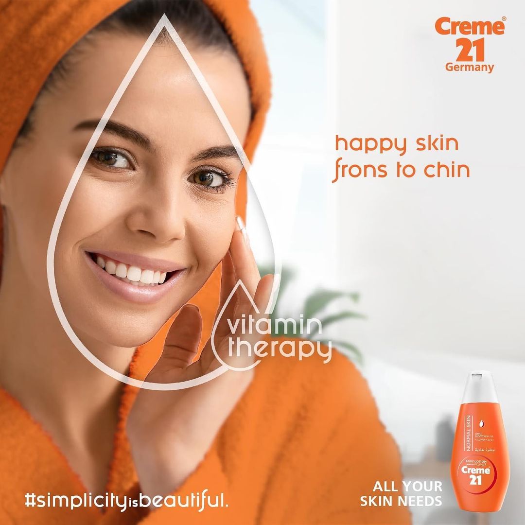 Creme 21 Germany skincare advertisement featuring smiling woman in orange towel promoting vitamin therapy products.