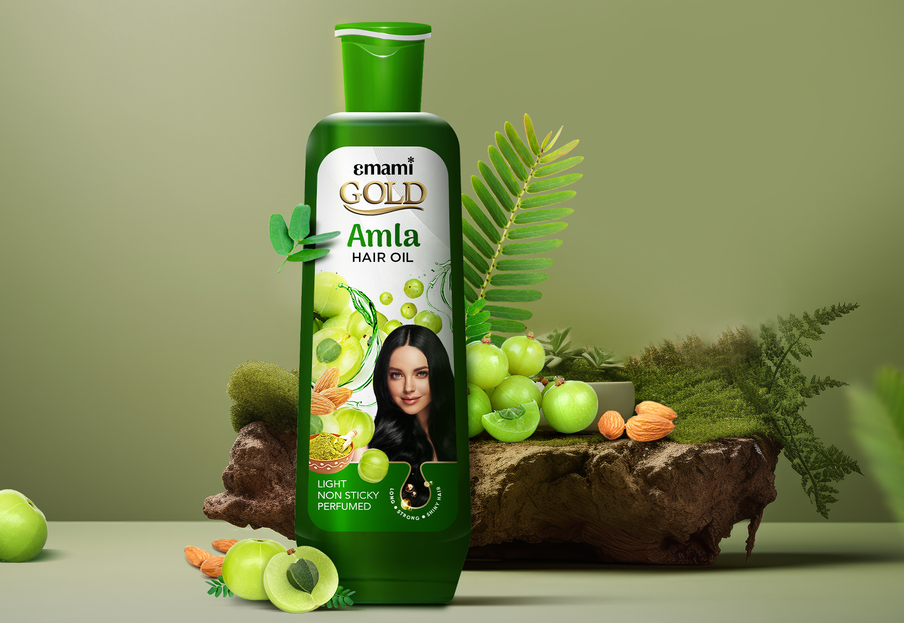 Emami Gold Amla Hair Oil bottle surrounded by fresh amla fruit, almonds, and green leaves on a natural display.