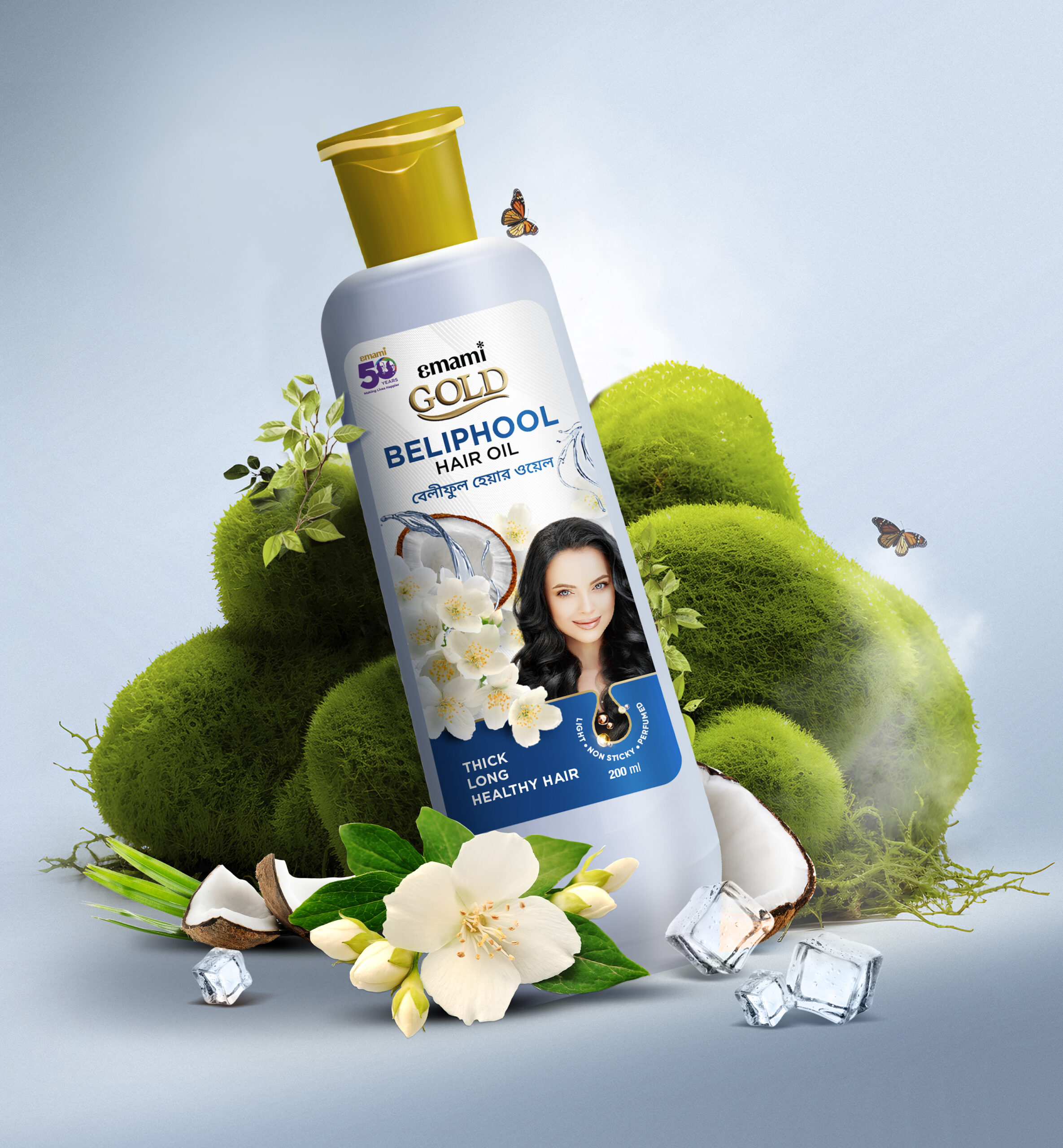 Emami Gold Beliphool Hair Oil bottle with jasmine flowers, coconut, ice cubes, and butterflies in a green natural setting.