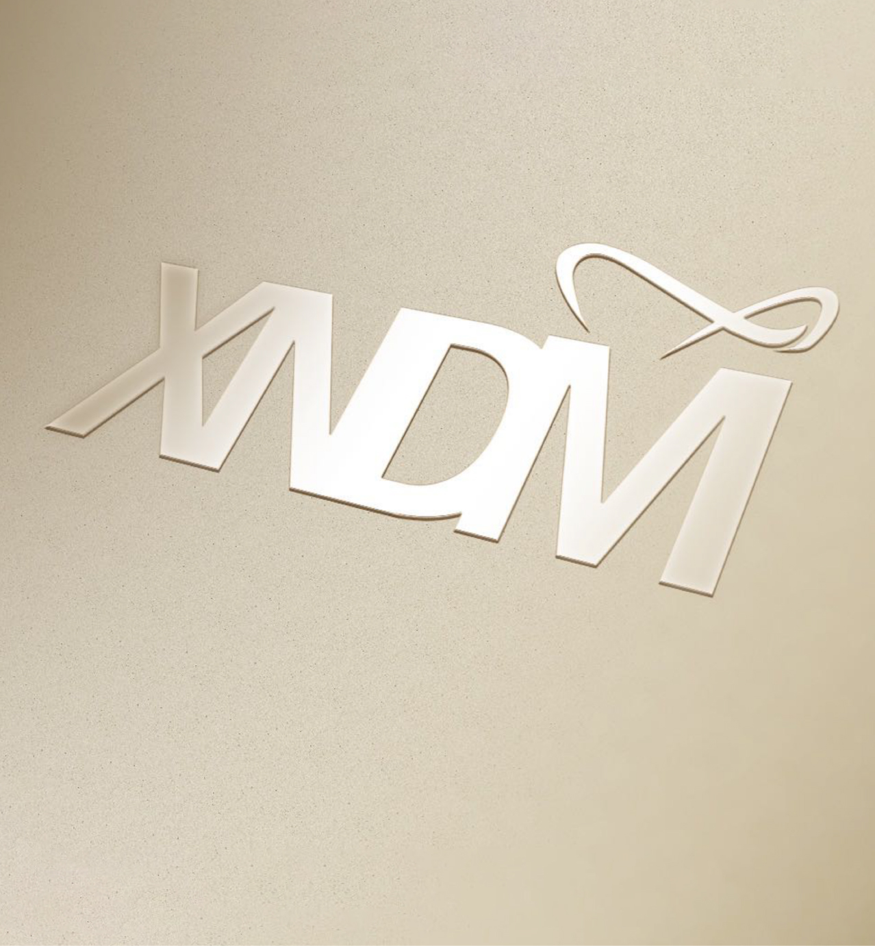 Elegant metallic logo with the letters "XDM" in a modern font and a swoosh accent above the letter M on a beige background.