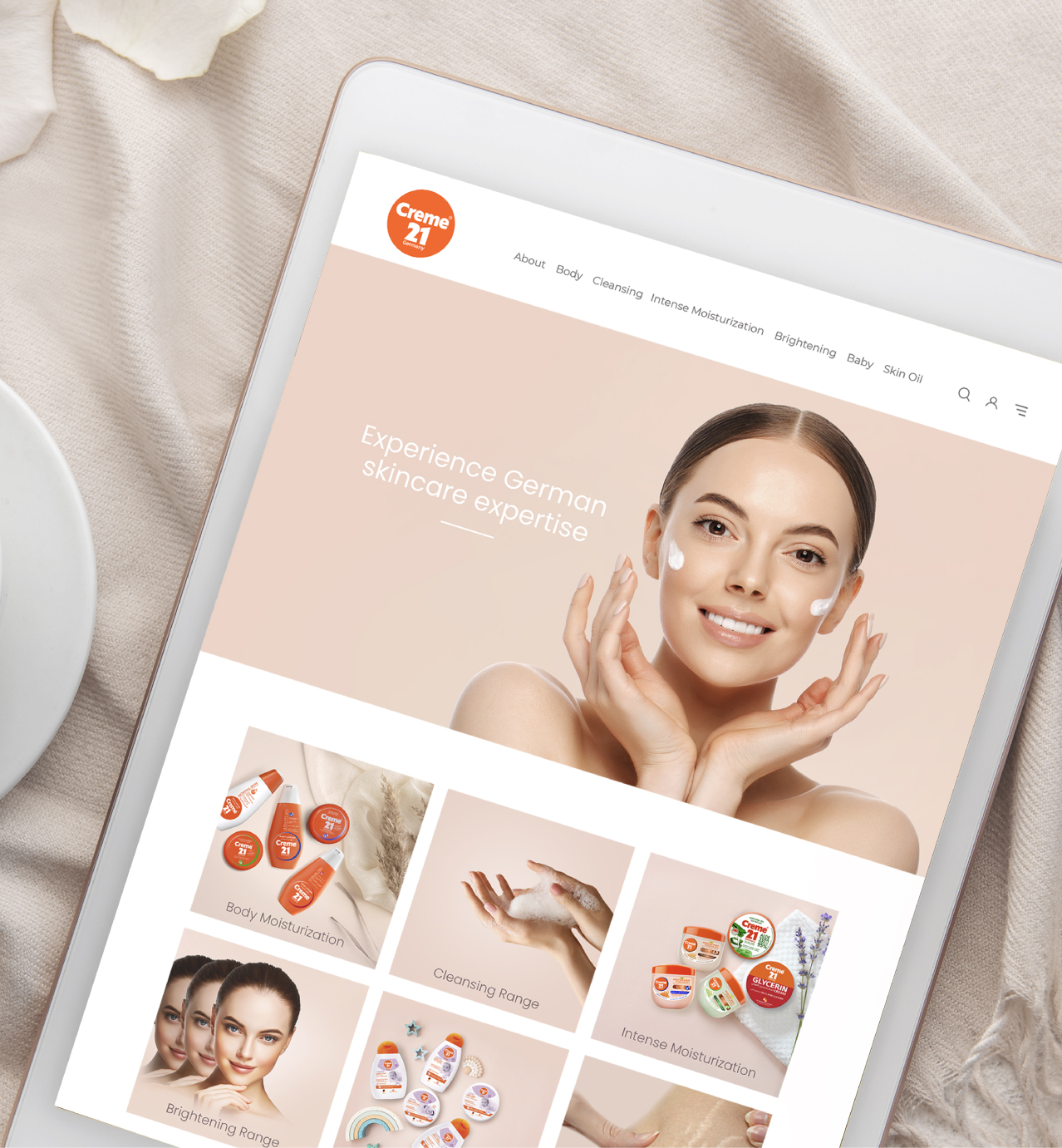 Creme 21 skincare website displayed on a tablet, showing product categories and the tagline "Experience German skincare expertise."
