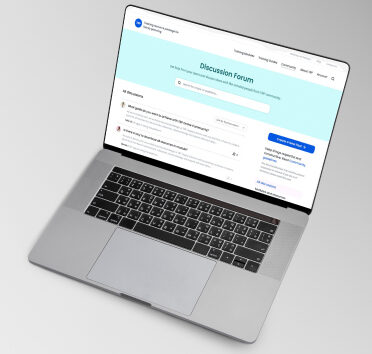 Laptop displaying an online discussion forum with user questions and a search bar on a light blue background.