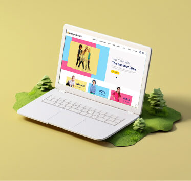 White laptop on grassy base displaying kids’ summer fashion website with colorful banners and images.
