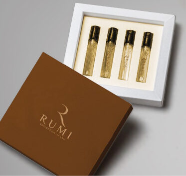 Rumi "Reflection of You" brown box with four perfume sample vials displayed in a white tray on a light surface