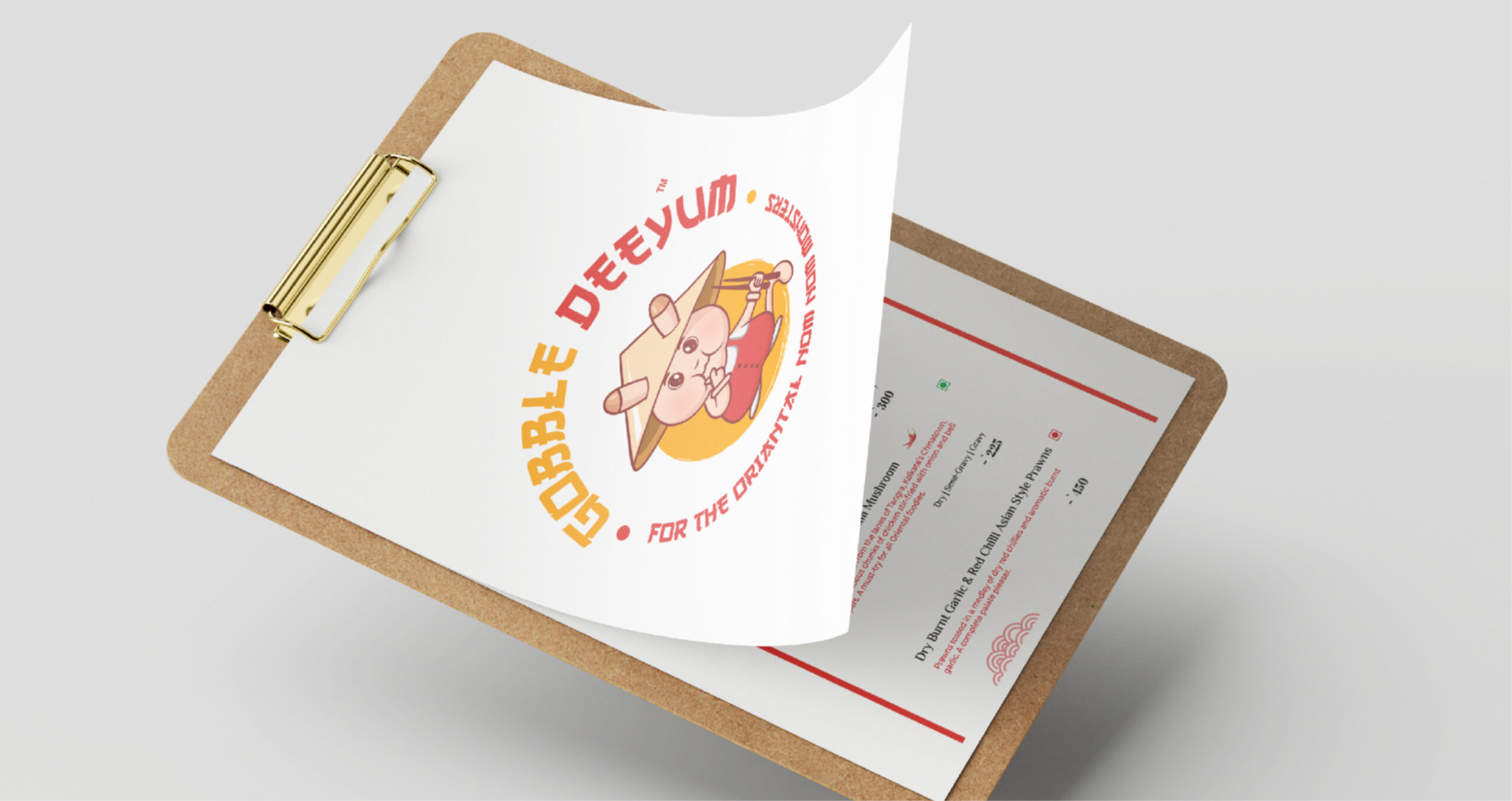 Clipboard with Gobble Deeyum logo featuring a cute cartoon character and tagline, partially revealing an Asian-style menu underneath.