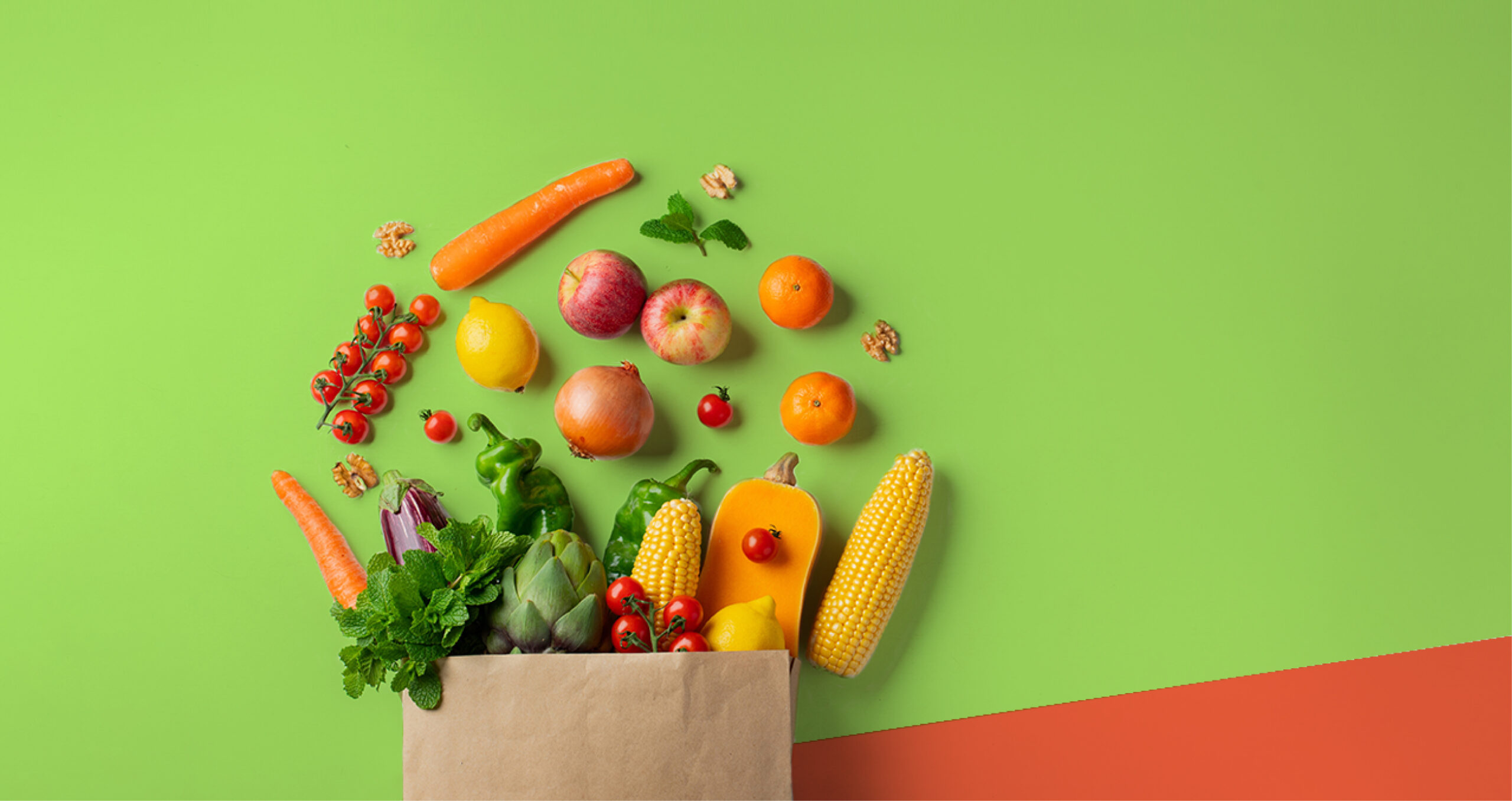 A brown paper bag filled with assorted fresh fruits, vegetables, nuts, and herbs on a green and orange background.