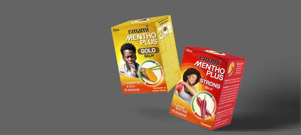Emami Mentho Plus Gold Balm and Strong Balm boxes with images of turmeric, lemongrass, and chilies for pain and cold relief.