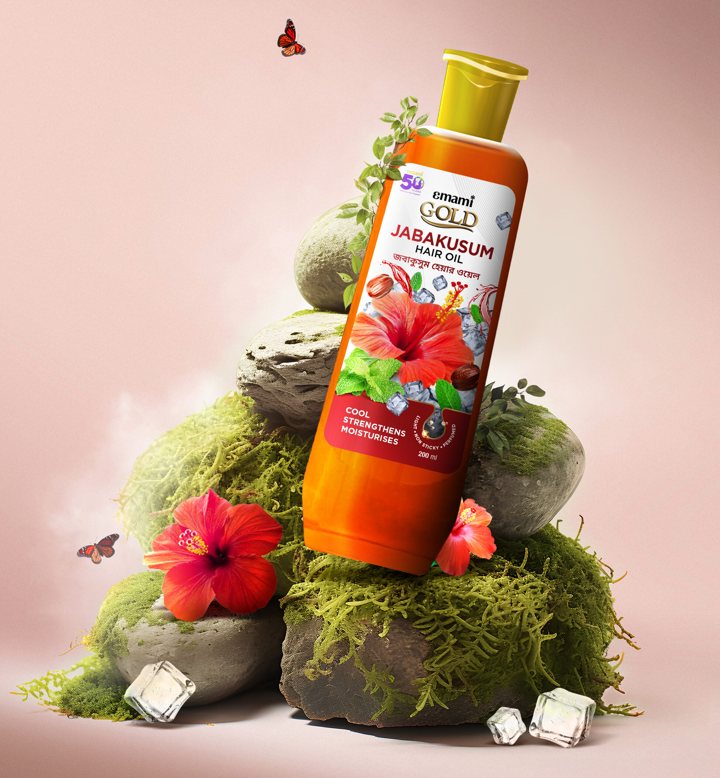 Emami Gold Jabakusum Hair Oil bottle with hibiscus flowers, nuts, mint leaves, ice cubes, and butterflies in a lush setting