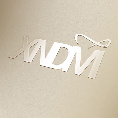 Sleek embossed logo reads "XDM" in stylized letters with an infinity symbol above the M.